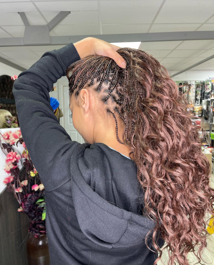 Knotless braids with curly ends in a high ponytail